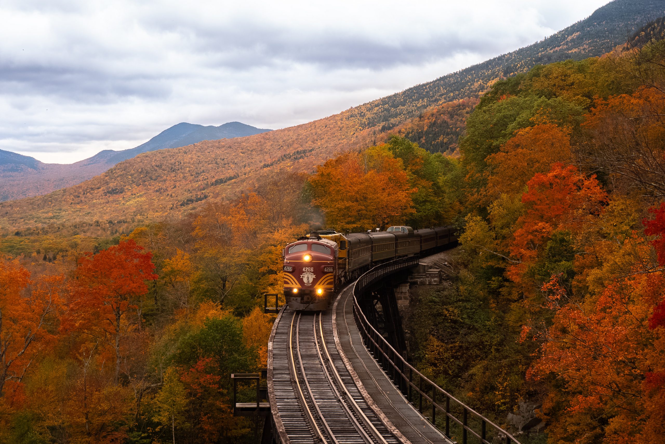 Train coming out of a tunnel in a colorful autumn scene in the mountains is used here to think of staying on track with our character choices